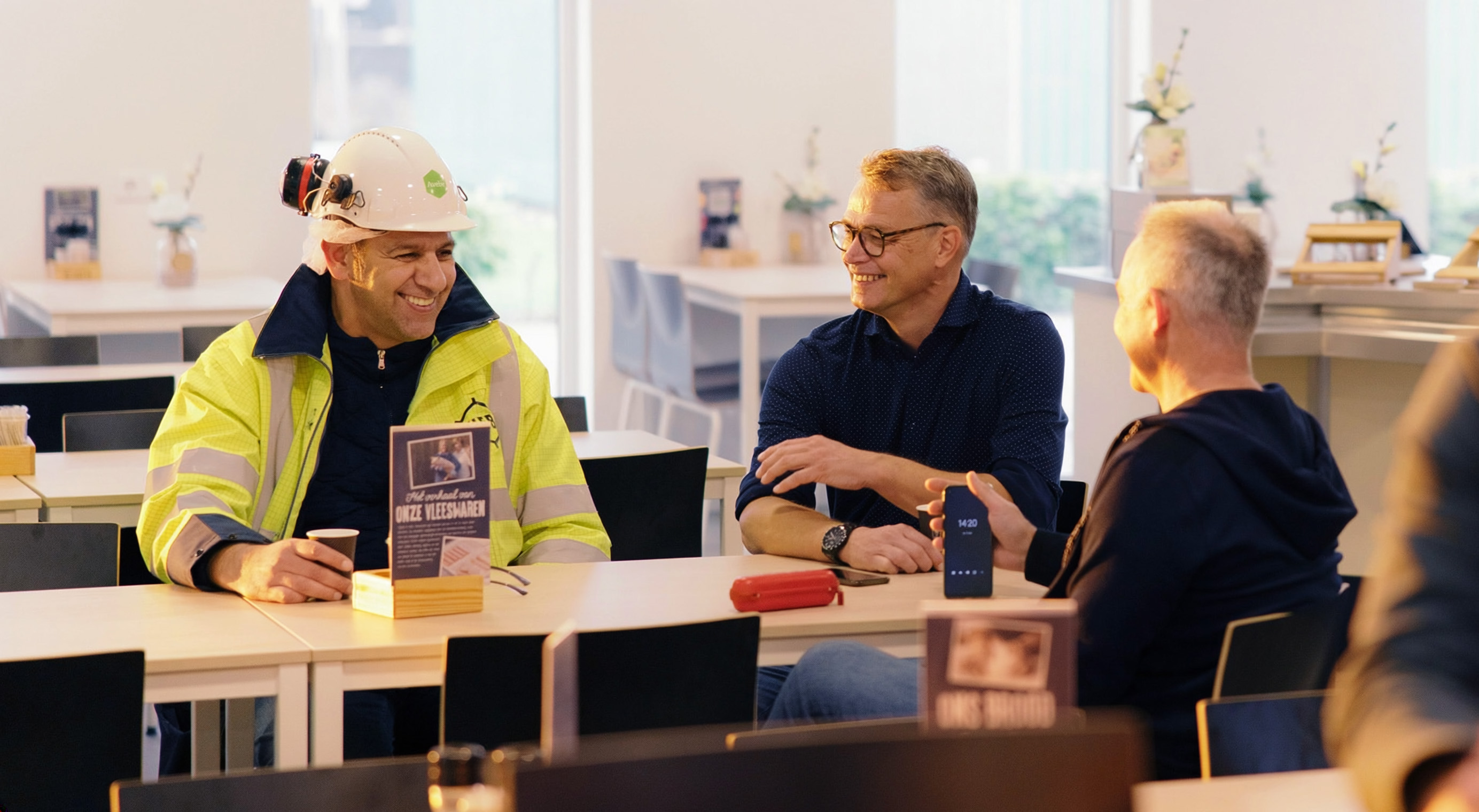 Vrouw in winkel glimlacht met een mobiel in haar hand.
